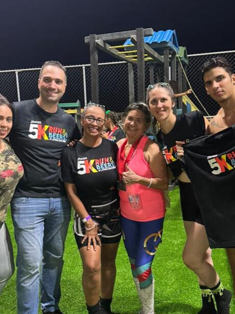 Participants and volenteers posing for picture with organizer of event